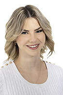 Junge Frau mit schulterlangen blonden Haaren lächelt freundlich vor weißem Hintergrund